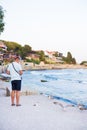 A young guy is feeding a flock of seagulls. Sun, summer, sea. Royalty Free Stock Photo