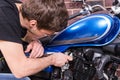 Young Guy Fixing his Motorbike with Wrench Tool Royalty Free Stock Photo