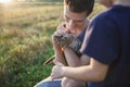 Young guy found and picked up little kitten during walking in field, homeless domestic animals care Royalty Free Stock Photo