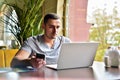 Young guy is freelancer in cafe working behind laptop Royalty Free Stock Photo