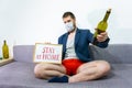 Young guy freelancer relaxing at home and drink wine. Cozy time at home. Self time and Coronavirus outbreak quarantin