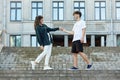 Young guy and a girl on the street. the guy holds the girl`s hand, and they take a step towards each other