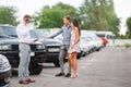 A young couple is choosing a used car. Used car theme.