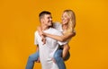 Young guy giving piggyback ride to his girlfriend Royalty Free Stock Photo
