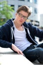 Young guy with glasses sitting outdoors Royalty Free Stock Photo