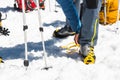 A young guy hiker dresses climbing Crampons over mountaineering shoes For walking through Glacier