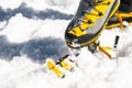 A young guy hiker dresses climbing Crampons over mountaineering shoes For walking through Glacier