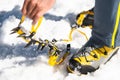 A young guy hiker dresses climbing Crampons over mountaineering shoes For walking through Glacier