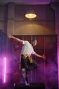 Young guy hiphop performer break dancing in neon club lighting