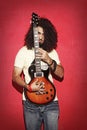 Young guy holding an electric guitar beautiful long curly hair Royalty Free Stock Photo