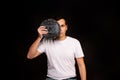 A young guy holds a symbol of the DASH coin, a modern currency for exchange and purchases