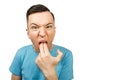 Young guy inserts two fingers in the mouth to induce vomiting, on a isolated white background Royalty Free Stock Photo