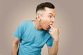 Young guy inserts two fingers in the mouth to induce vomiting, on a light background Royalty Free Stock Photo
