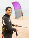 Young guy with kiteboard at the beach