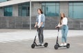 Young guy and lady having ride on electric kick scooter Royalty Free Stock Photo
