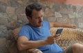 Young guy looking cellphone worried reading the news and having feeling of doubt and confused. Disappointment man holding device