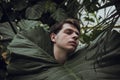 A young guy is lying on the bushes, the concept of unity with nature, cares about nature, spring has come Royalty Free Stock Photo