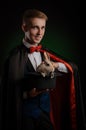 A young guy magician illusionist holding a hat with a rabbit