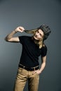 Young guy model posing in a tankman helmet on the gray background