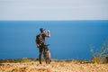 A young guy on a mountain bike stopped to drink water from a jar on a stony road near the Mediterranean Sea in Spain.