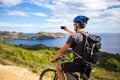 A young guy on a mountain bike trails in Spain and takes a photo on a white phone in the background of the Mediterranean sea of th Royalty Free Stock Photo