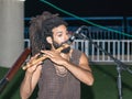 A young guy plays a flute in the evening on the waterfront in the city of Nahariya, in Israel