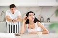 Young guy quarrels with young woman in kitchen Royalty Free Stock Photo