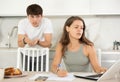 Young guy quarrels with young woman working at laptop Royalty Free Stock Photo