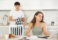 Young guy quarrels with young woman working at laptop Royalty Free Stock Photo