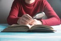 A young guy reading a book with a magnifying glass Royalty Free Stock Photo