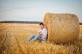 Young guy is relaxing in the countryside with a guitar. Plays the guitar . Resting lying on the hay Royalty Free Stock Photo