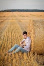 Young guy is relaxing in the countryside with a guitar. Plays the guitar . Resting lying on the hay Royalty Free Stock Photo