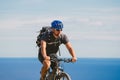 Young guy riding a mountain bike on a bicycle route in Spain. Athlete on a mountain bike rides off-road against the background of Royalty Free Stock Photo