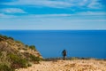 A young guy riding a mountain bike on a bicycle route in Spain on road against the background of the Mediterranean Sea. Dressed in Royalty Free Stock Photo