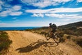 A young guy riding a mountain bike on a bicycle route in Spain on road against the background of the Mediterranean Sea Royalty Free Stock Photo