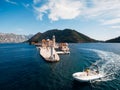 Young guy sailing on a boat on the sea on a sunny summer day. The bride and groom stand on the pier against the