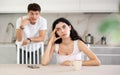 Young guy quarrels with young woman in kitchen Royalty Free Stock Photo