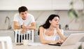 Young guy quarrels with young woman working at laptop Royalty Free Stock Photo