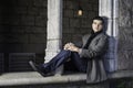 A young guy is sitting on a old window frame outside in New York City Royalty Free Stock Photo