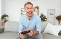 Young guy sitting on sofa playing video games Royalty Free Stock Photo