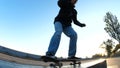 Young guy slides on a skateboard along the ledge, close up