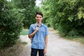 Young guy student stands in a shirt with a backpack on the road Royalty Free Stock Photo