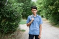 Young guy student stands in a shirt with a backpack on the road Royalty Free Stock Photo