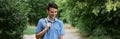 Young guy student stands in a shirt with a backpack on the road Royalty Free Stock Photo