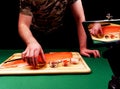 A young guy takes picture of fillet that are fresh raw salmon and holds a