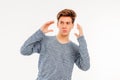 Young guy teenager is surprised, hands behind his head and looks away Royalty Free Stock Photo