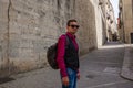 A young guy, a tourist admiring sights on a medieval street in G Royalty Free Stock Photo