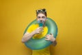 Young guy on vacation in the summer holds a blue cocktail on a yellow background