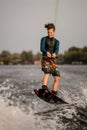 young guy wakeboarder holds rope in his hands and jumping on wave Royalty Free Stock Photo