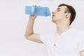 Young guy after a workout drink from a shaker. Isolated white background Royalty Free Stock Photo